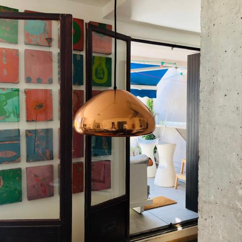 une lampe suspendue dans une pièce avec un miroir dans l'établissement Marseille Joliette Panier, vue mer et Terrasse T1, à Marseille