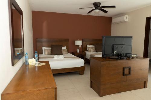 a hotel room with two beds and a television at Quinto Sole in Mahahual