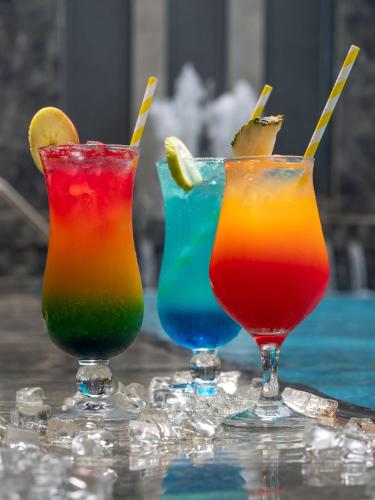 three colorful cocktails sitting on top of a table at Radisson Lagos Ikeja in Lagos