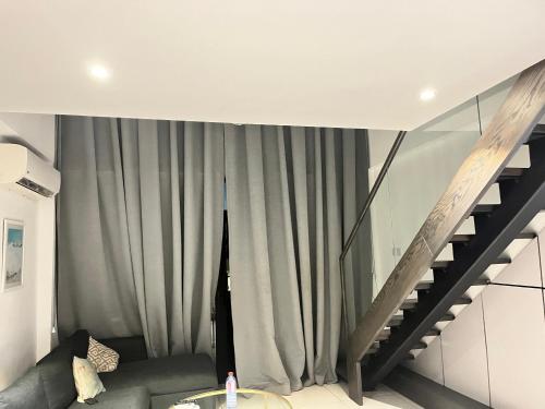 a living room with a couch and a staircase at Embassy Gardens Royal Suites Apartments in Accra
