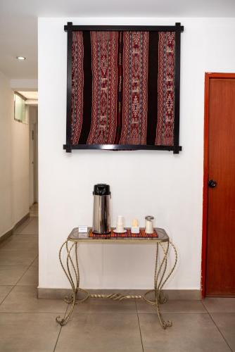 a table with a coffee pot on a wall at Hotel San Pedro Plaza in Cusco