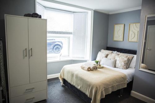 a bedroom with a bed with a dresser and a window at Central Studio Apartments in Stratford upon Avon in Shottery