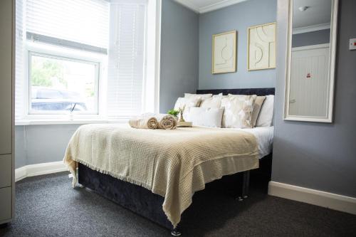 a bedroom with a bed with a blanket and a window at Central Studio Apartments in Stratford upon Avon in Shottery