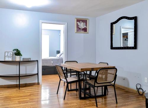 a dining room with a table and chairs and a mirror at Lovely Loft in Newark Minutes from NYC, EWR & American Dream Mall in Newark