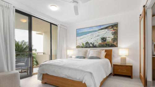 a bedroom with a bed with a painting on the wall at Unit 3 21 Park Generous and Comfortable Beachside Abode in Sunshine Beach