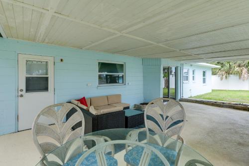 a patio with chairs and a couch on a porch at Pet-Friendly Cocoa Beach Home Walk to Beach! in Cocoa Beach