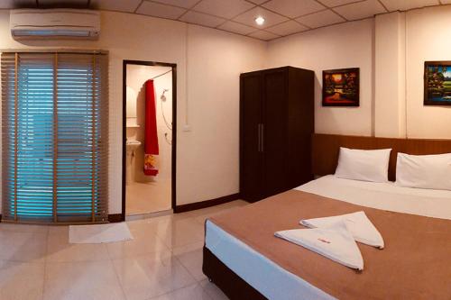 a bedroom with a bed with a robe on it at Lodge 61 Hotel in Bangkok