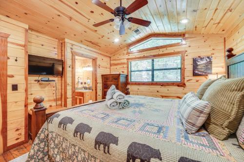 a bedroom with a bed and a ceiling fan at Cabin with Hot Tub and Wraparound Deck in Broken Bow! in Broken Bow