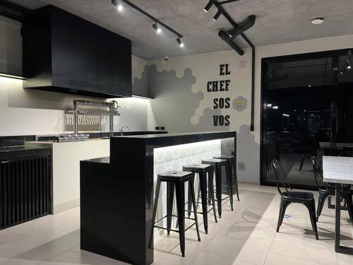 a kitchen with a counter with stools in it at Elegante en Nanotec in El Pary