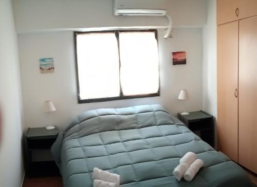 a room with a blue couch in a room with two windows at Departamento a 150 metros de la catedral con cochera in San Fernando del Valle de Catamarca