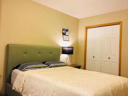 a bedroom with a large bed with a green headboard at Bedrooms in Kenaston, Close to Walmart, Costco, IKEA, Outlet in Winnipeg