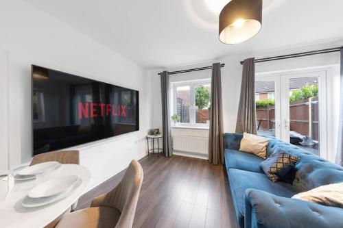 a living room with a blue couch and a table at The Bridge 2 Bedroom House in Dartford