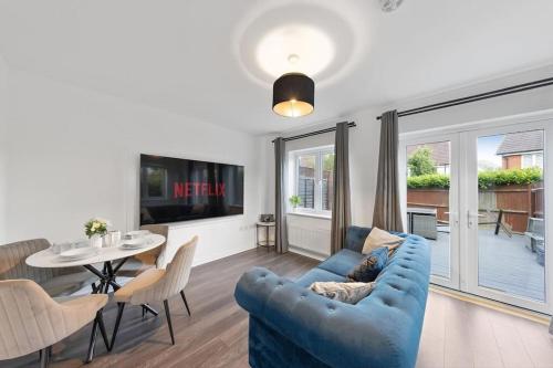a living room with a blue couch and a table at The Bridge 2 Bedroom House in Dartford