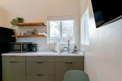 a kitchen with a sink and a microwave and a window at Casitas at Capitol Reef in Torrey