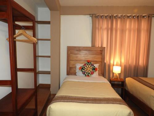a small bedroom with a bed and a bunk bed at Ayllu B&B Ollantaytambo in Ollantaytambo