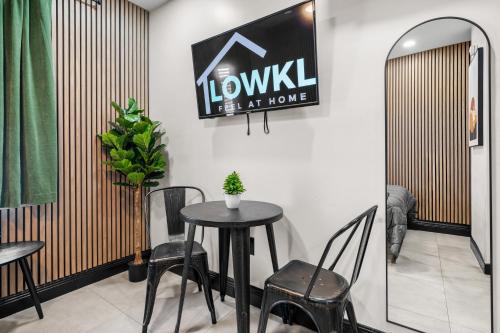 a table and chairs in a room with a sign on the wall at Baybreeze Apartments by Lowkl in Miami Beach