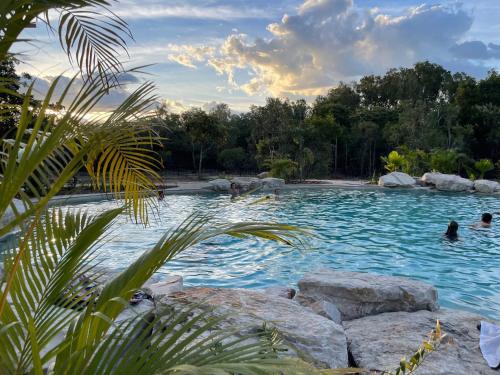 a pool at a resort with people in the water at Litchfield Safari Camp in Rakula