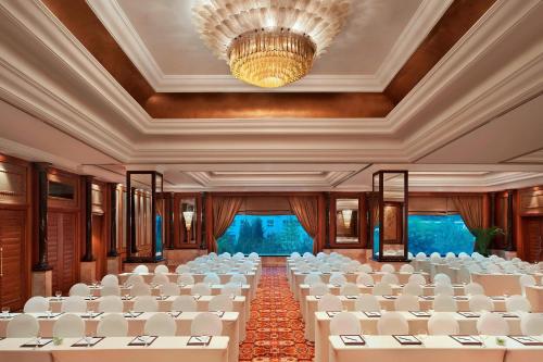 a banquet hall with white chairs and a chandelier at The St. Regis Beijing in Beijing