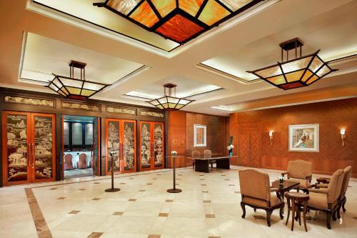 a lobby with a table and chairs and a glass ceiling at The St. Regis Beijing in Beijing