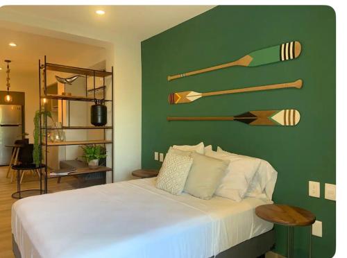 a bedroom with a bed with a green wall with wooden oars at Estudio remodelado en Marina Vallarta in Puerto Vallarta