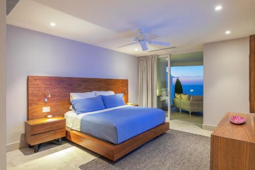 a bedroom with a bed with a blue comforter and blue pillows at 4 BR Casa Indah is a Gorgeous New 3400 SF Condo in Puerto Vallarta
