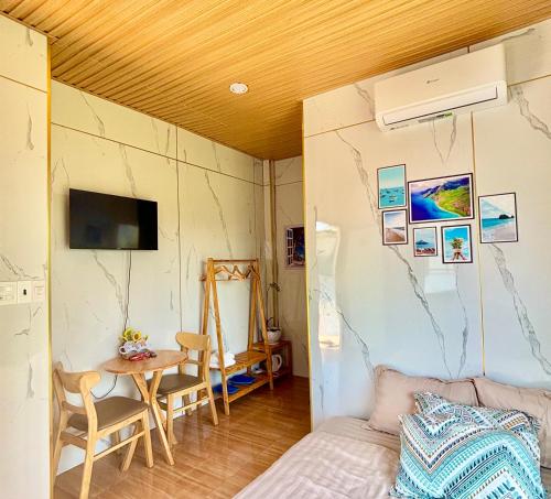 a room with a bed and a table and a tv at Homestay Vitamin SEA - View Biển Phú Quý in Cu Lao Thu