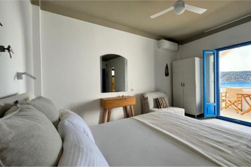 a bedroom with a bed and a view of the ocean at Eleni On The Beach in Katapola