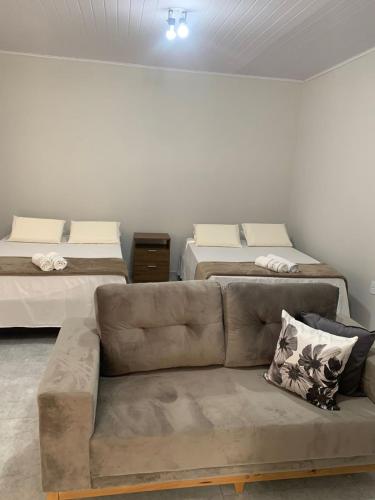 a living room with a couch and two beds at Recanto Catarina in Cunha
