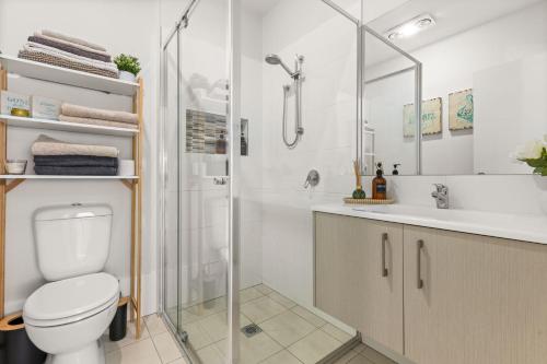 a bathroom with a shower and a toilet and a sink at The Bayswood Retreat on Moona Creek by Experience Jervis Bay in Vincentia