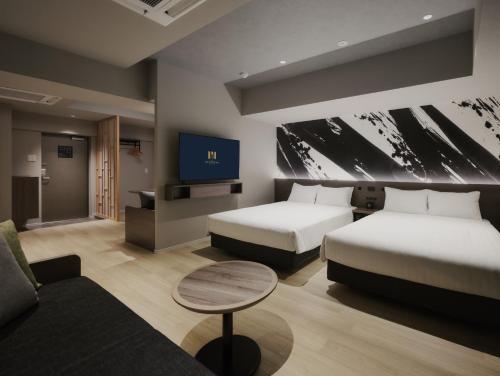 a hotel room with two beds and a tv at MONday Apart Premium Asakusa in Tokyo