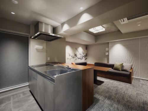 a kitchen with a sink and a couch in a room at MONday Apart Premium Asakusa in Tokyo