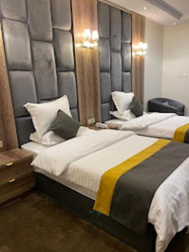 a bedroom with two beds and a headboard at شقق اضواء رفا للشقق المخدومة in Al Kharj