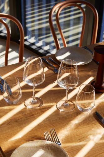 four wine glasses sitting on a wooden table at The Clairfield Hotel in Mudgee
