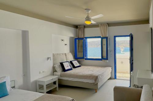 a bedroom with a bed and a window at Eleni On The Beach in Katapola