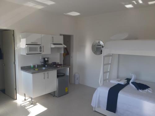 a bedroom with a bed and a kitchen with a sink at Casablanca207 in Acapulco