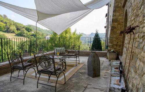 a patio with a table and chairs on a balcony at Stunning Home In Macerata Feltria in Macerata Feltria
