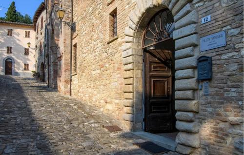 a brick building with a wooden door on a street at Stunning Home In Macerata Feltria in Macerata Feltria
