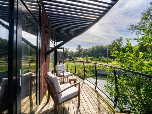 a balcony with two chairs and a view of a river at Relaxing Nature Getaway in Antoing