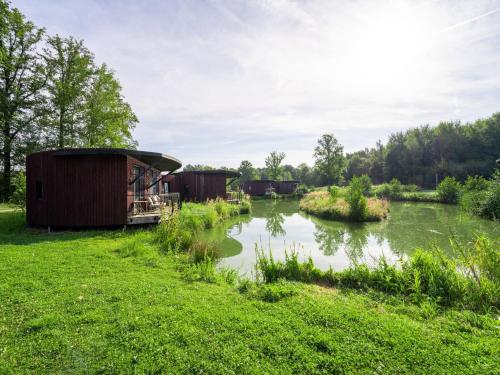 a group of small buildings on the side of a river at Relaxing Nature Getaway in Antoing