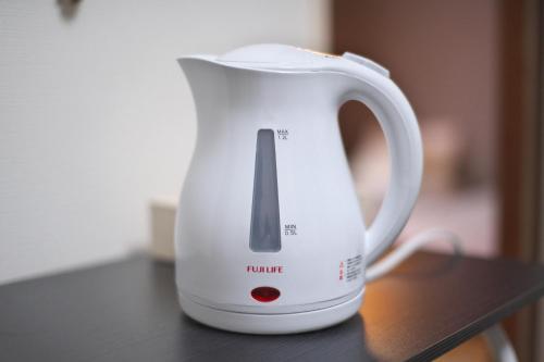 a white electric kettle sitting on a table at Zen Abode404 Japanese-style and modern Western-style rooms in Tokyo
