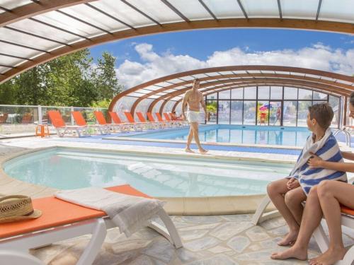 Quelques personnes assises autour d'une piscine dans l'établissement Mobilhome familial 3 chambres, à Onzain