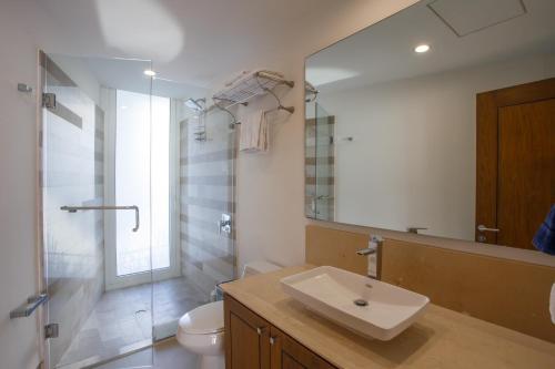 a bathroom with a sink and a toilet and a mirror at 1 BR Stunning View 1200 SF Loft Penthouse with 2 Bathrooms in Puerto Vallarta