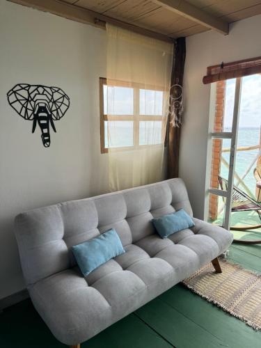 a living room with a couch with two blue pillows at Tequila SunBeach Baru Eco-Hotel in Baru