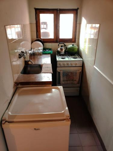 a small kitchen with a sink and a stove at Cabañas El Molino in Senador Pérez