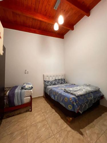 ein Schlafzimmer mit einem Bett in der Zimmerecke in der Unterkunft Hermosa quinta para disfrutar del lugar in Laguna Brava