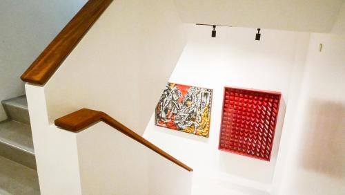 a staircase with two pieces of art on the wall at Cayco House by Hotel Durban in Manila