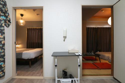 東京にあるZen Abode404 Japanese-style and modern Western-style roomsの鏡とテーブル付きの部屋、ベッドルーム1室