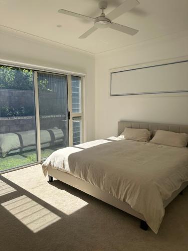 a bedroom with a bed and a large window at Surfleet Retreat Kiama in Kiama