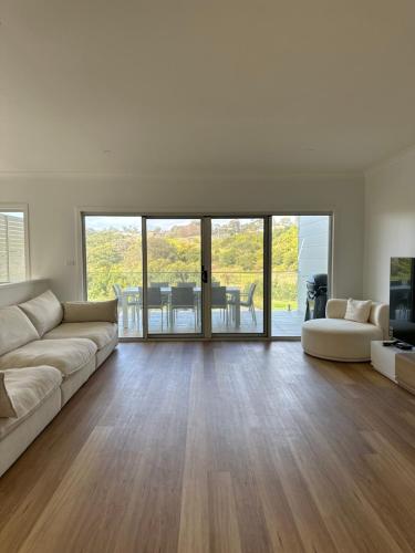 a living room with a couch and a television at Surfleet Retreat Kiama in Kiama
