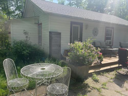 a patio with a table and chairs in front of a house at Enchanted Woodstock Cottage with hot tub in West Hurley